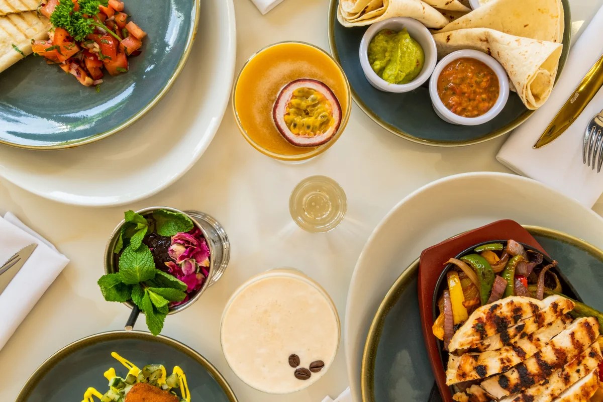 A varied spread of meals and plant foods on a dining table.