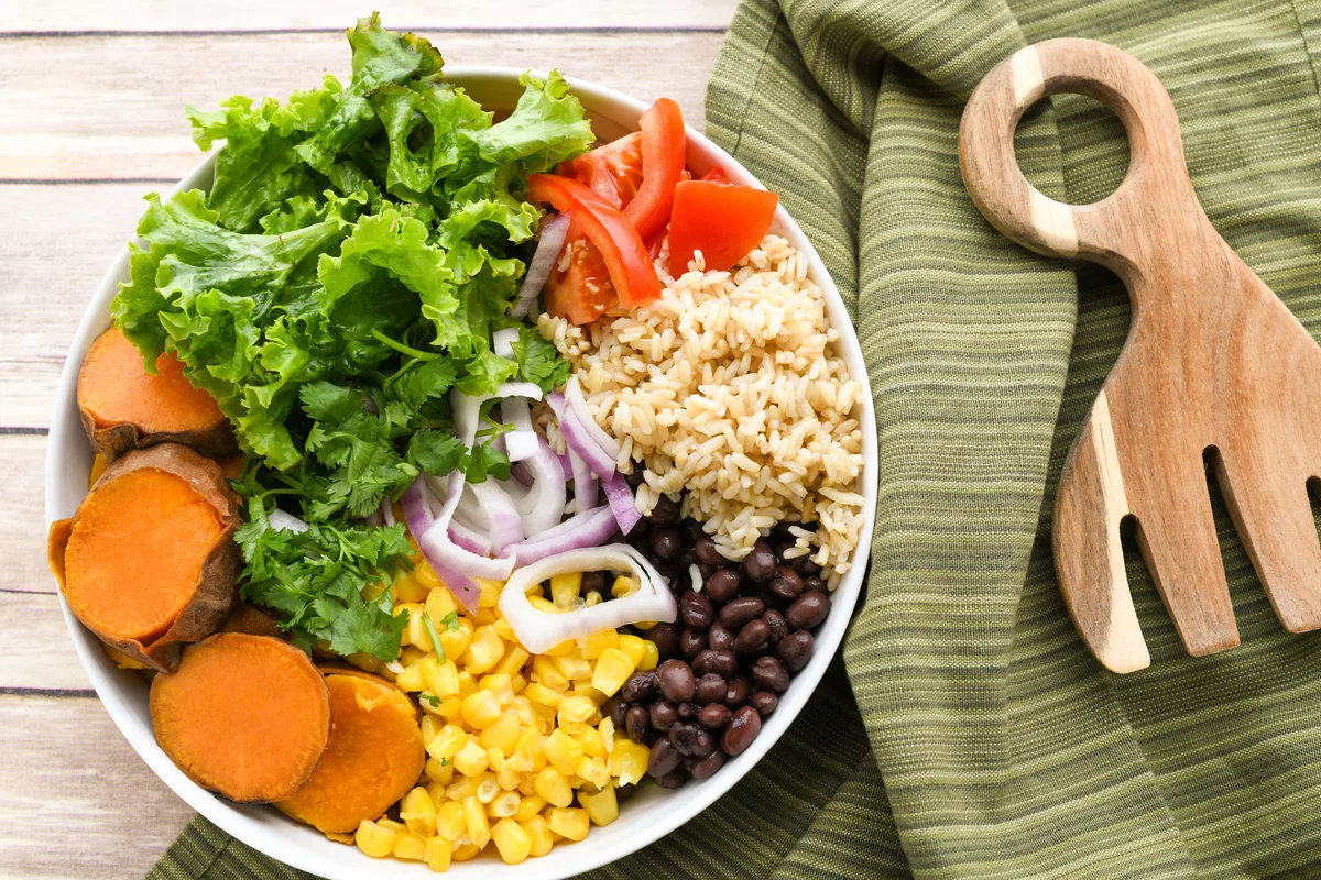 Mixed beans beside a simple vegetable and grain meal.