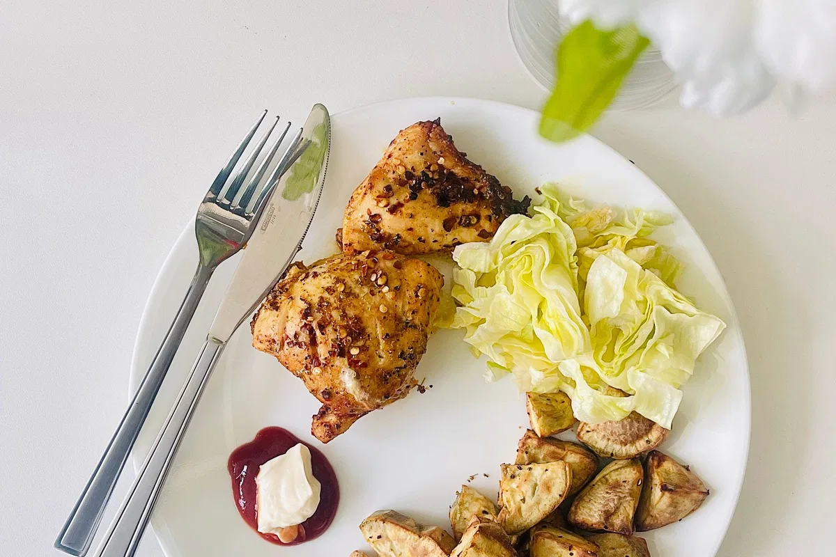 Grilled chicken served with vegetables and potatoes.