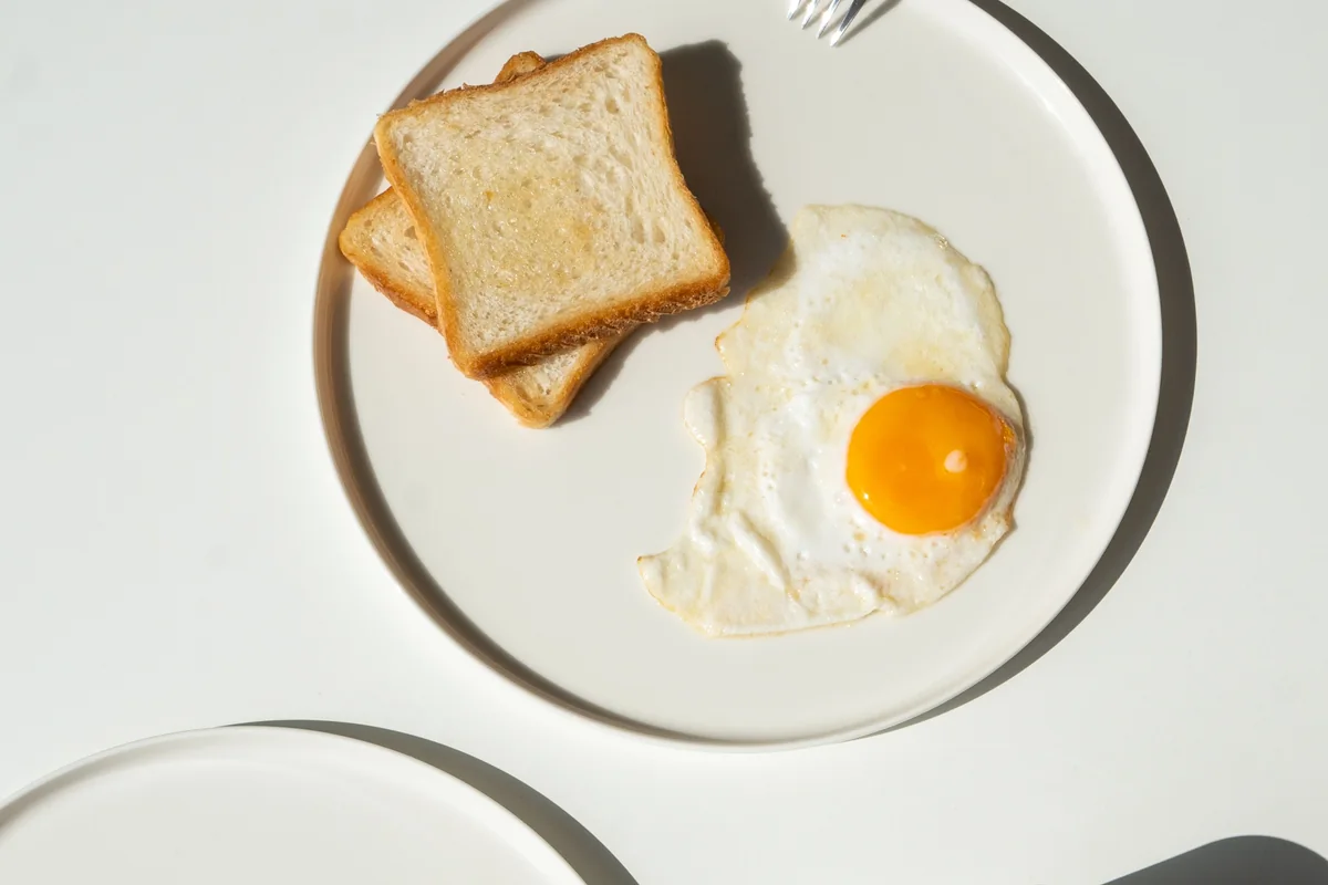 Eggs served with leafy greens and toast.