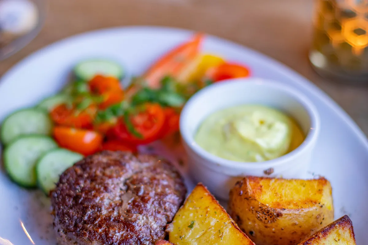 Roasted skin-on potatoes served with salad and grilled meat.