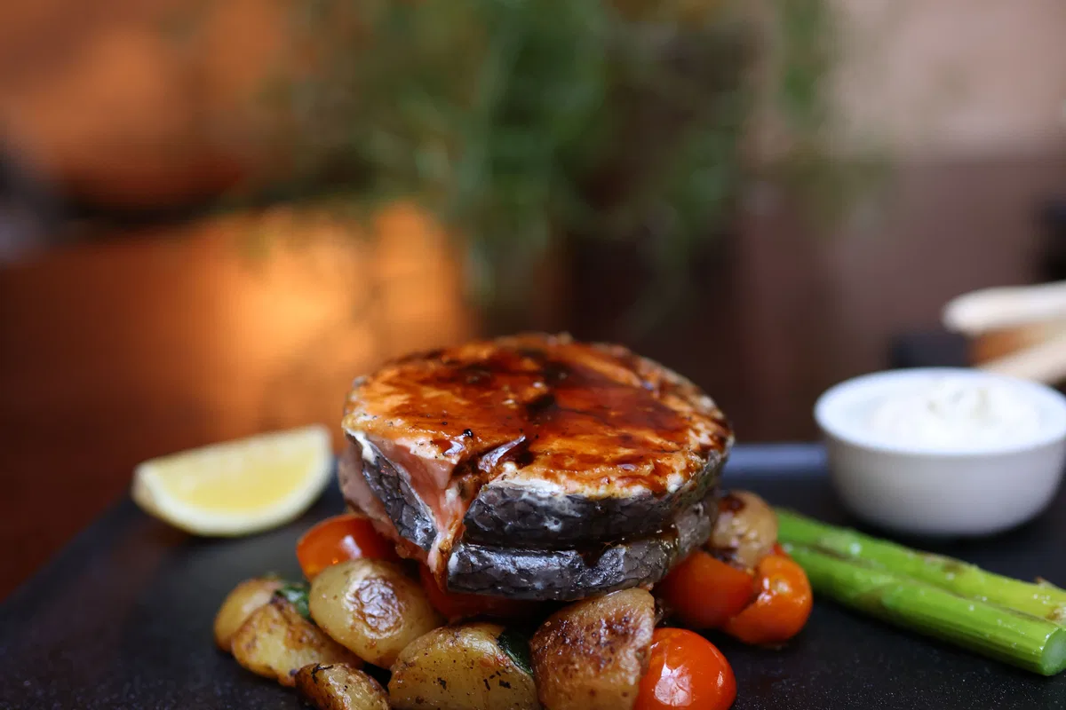 Grilled salmon served with vegetables and potatoes.