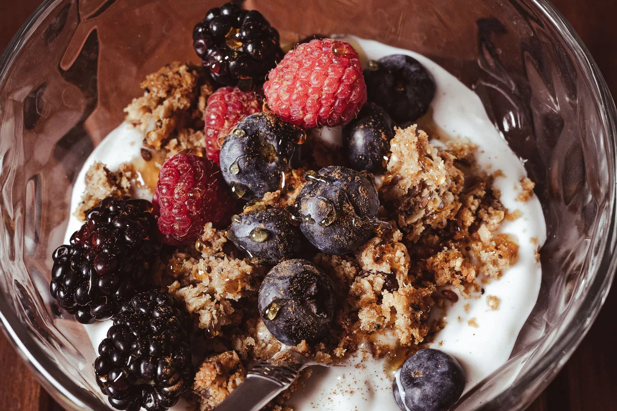 Yoghurt topped with mixed berries and a crunchy topping.