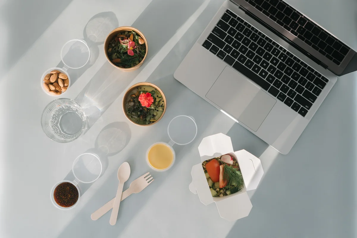 Home meal planning workspace with a laptop and balanced food choices.