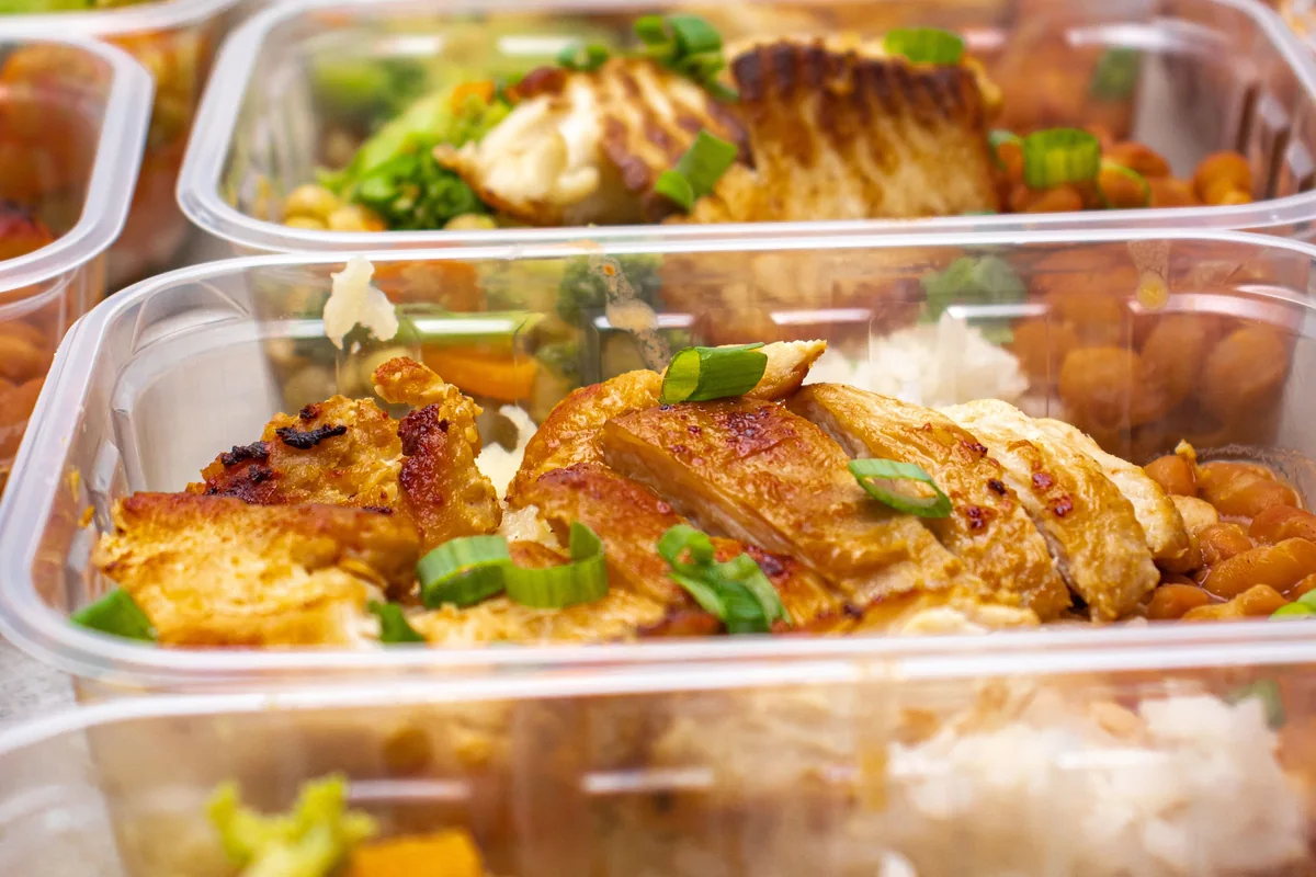 Prepared meal containers with vegetables, rice and chicken for a varied week.