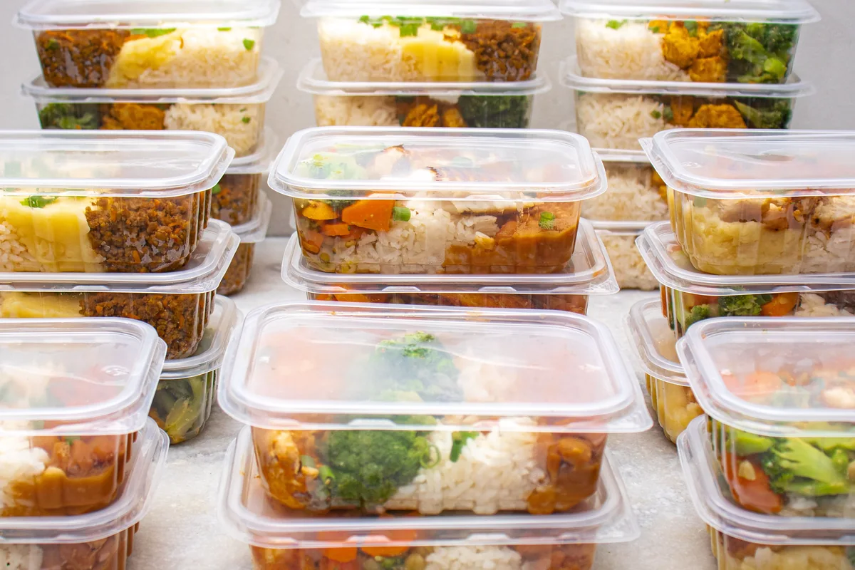 Multiple meal-prep containers filled with rice, vegetables and mixed meal components.