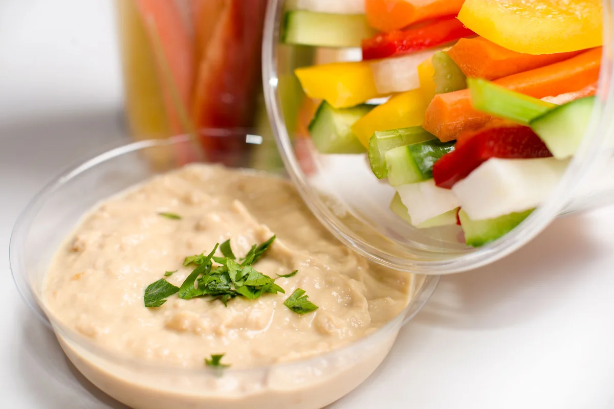 Hummus served with chopped cucumber, carrot, pepper and other crunchy vegetables.