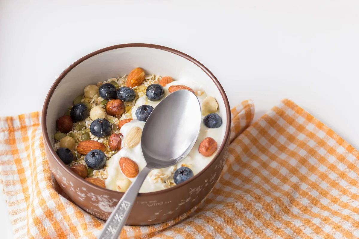 Plain yoghurt bowl topped with blueberries and mixed nuts