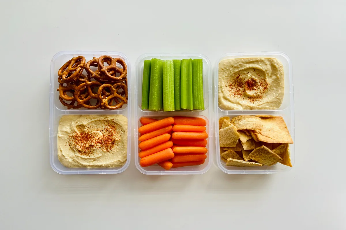 Packed snack boxes with hummus, crunchy vegetable sticks and crisp pitta pieces