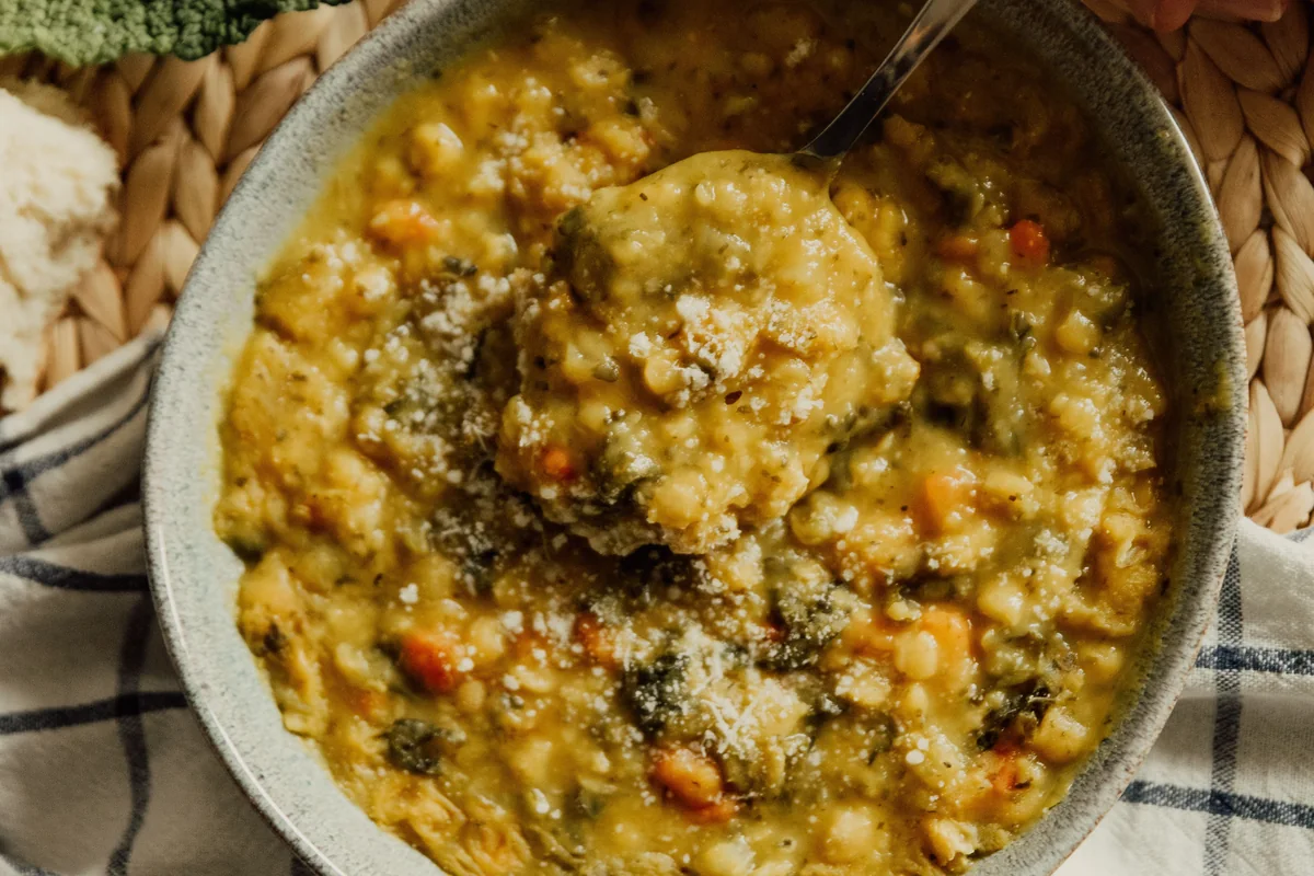 A bowl of thick lentil and vegetable stew seasoned with herbs.