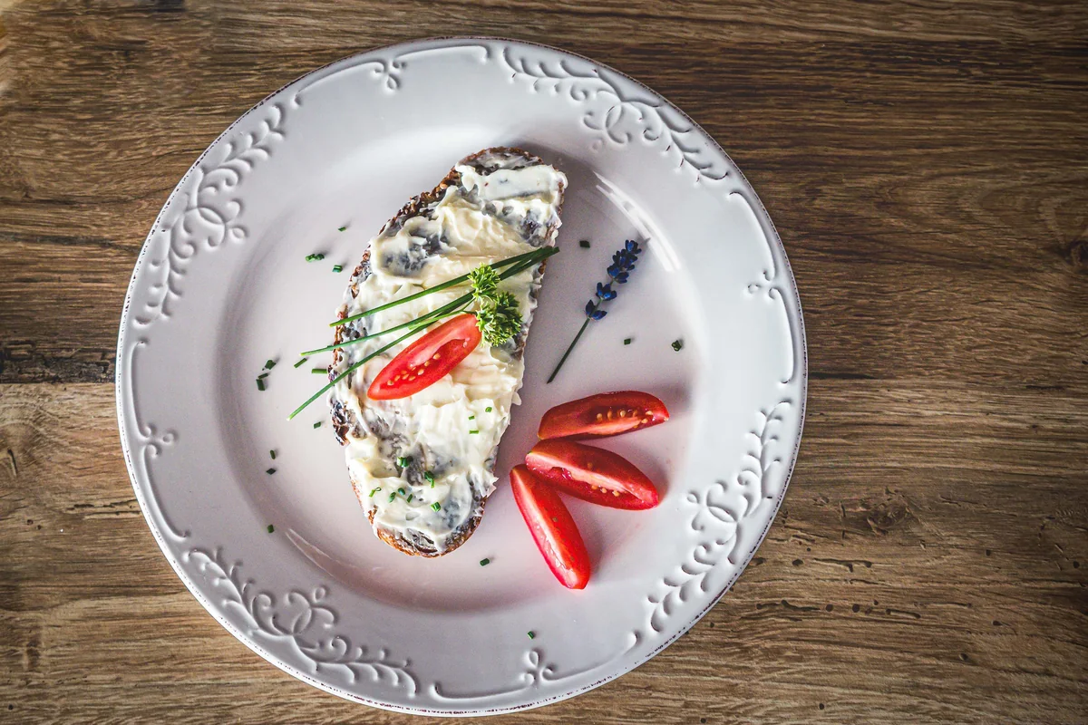 Open wholegrain bread topped with cottage cheese, cherry tomato and fresh chives
